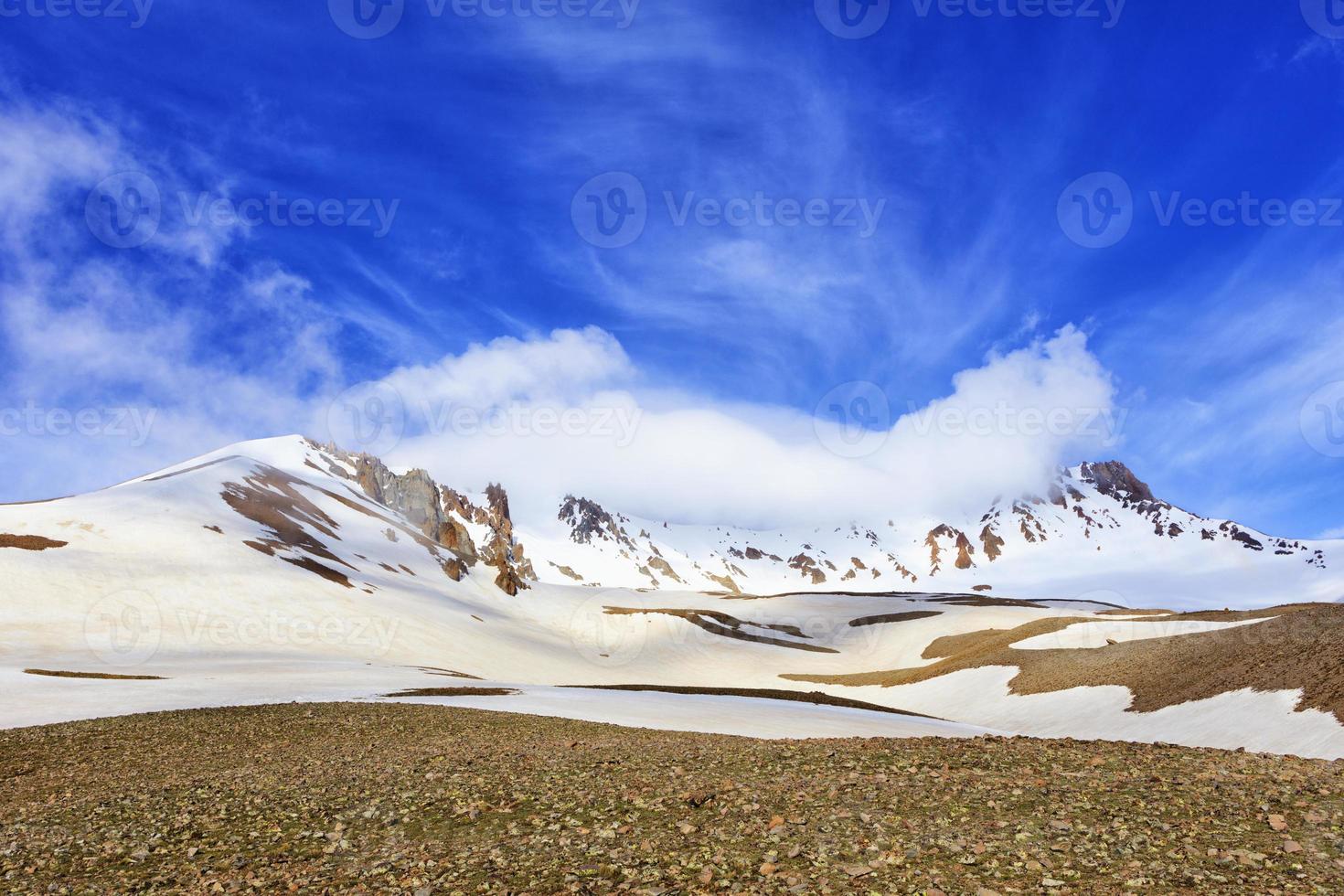 View of Mount Erciyas in central Turkey against a blue bright sky and white fog. photo