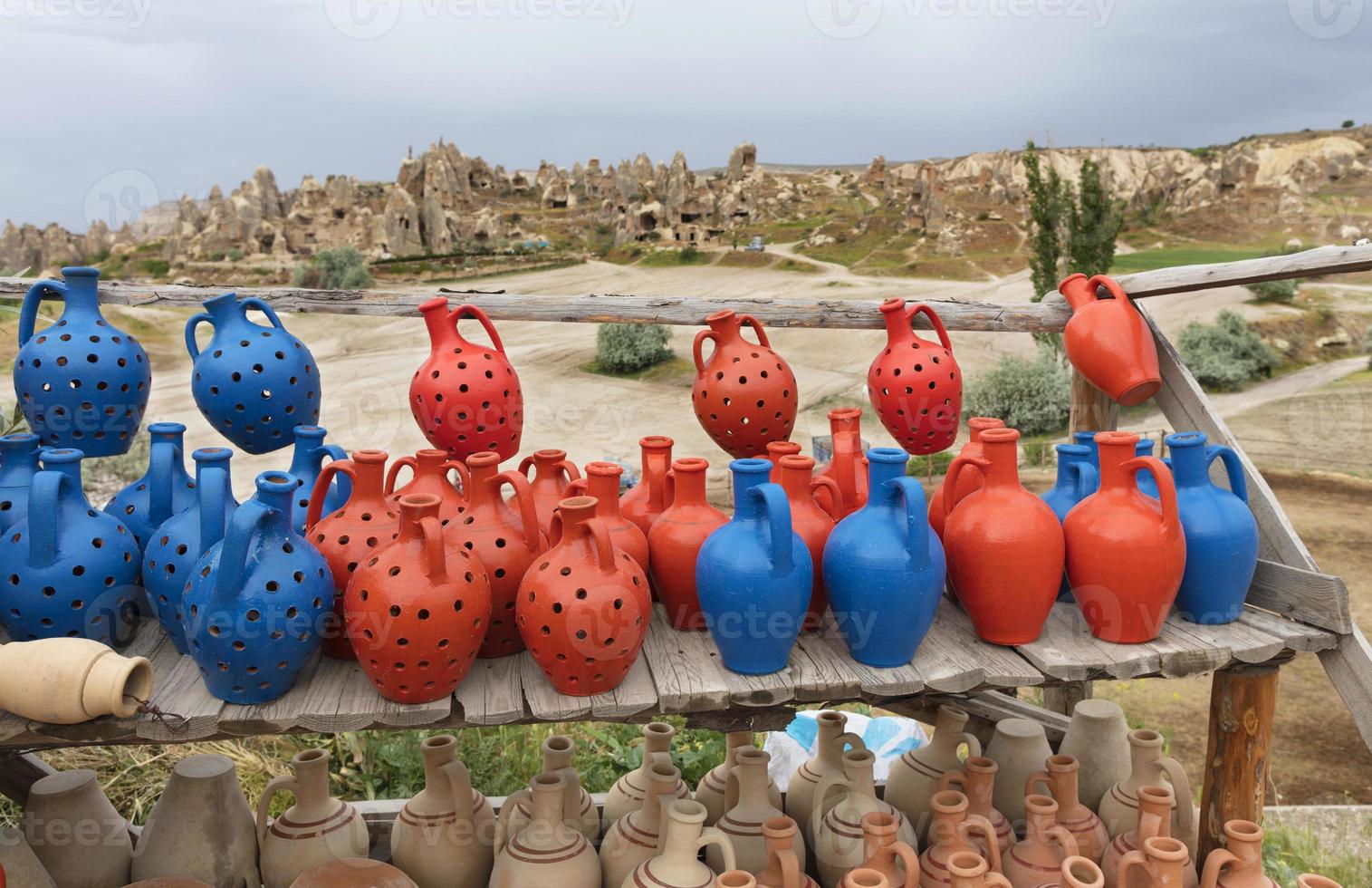 The multi-colored clay pots of desires stand on a wooden table in Cappadocia. photo