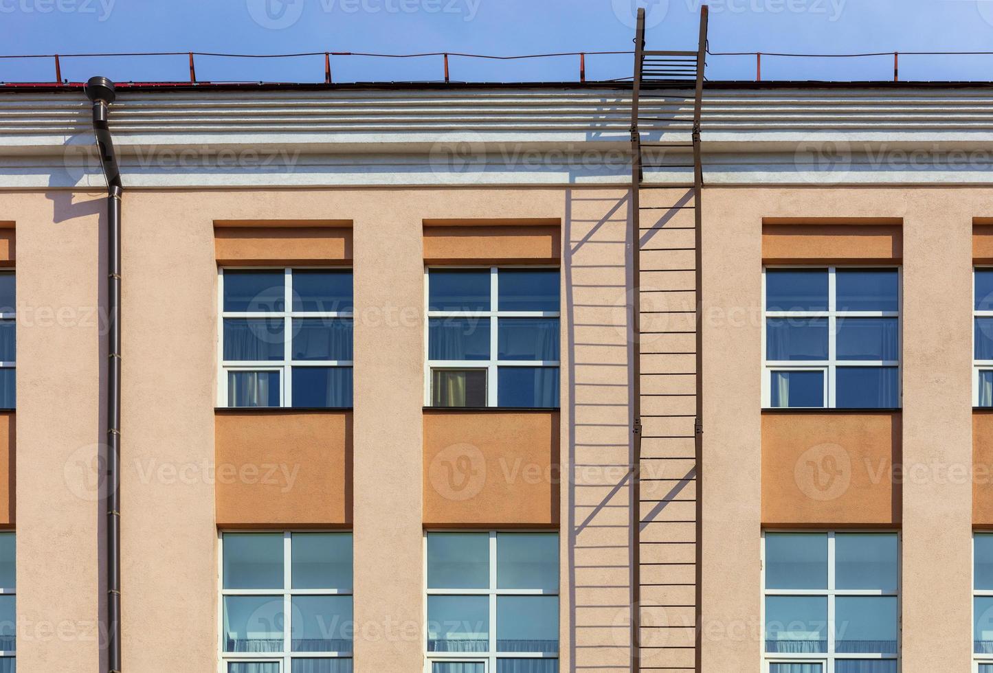 Renovation and renovation of the facade of a modern residential building with a fire escape and access to the roof. photo