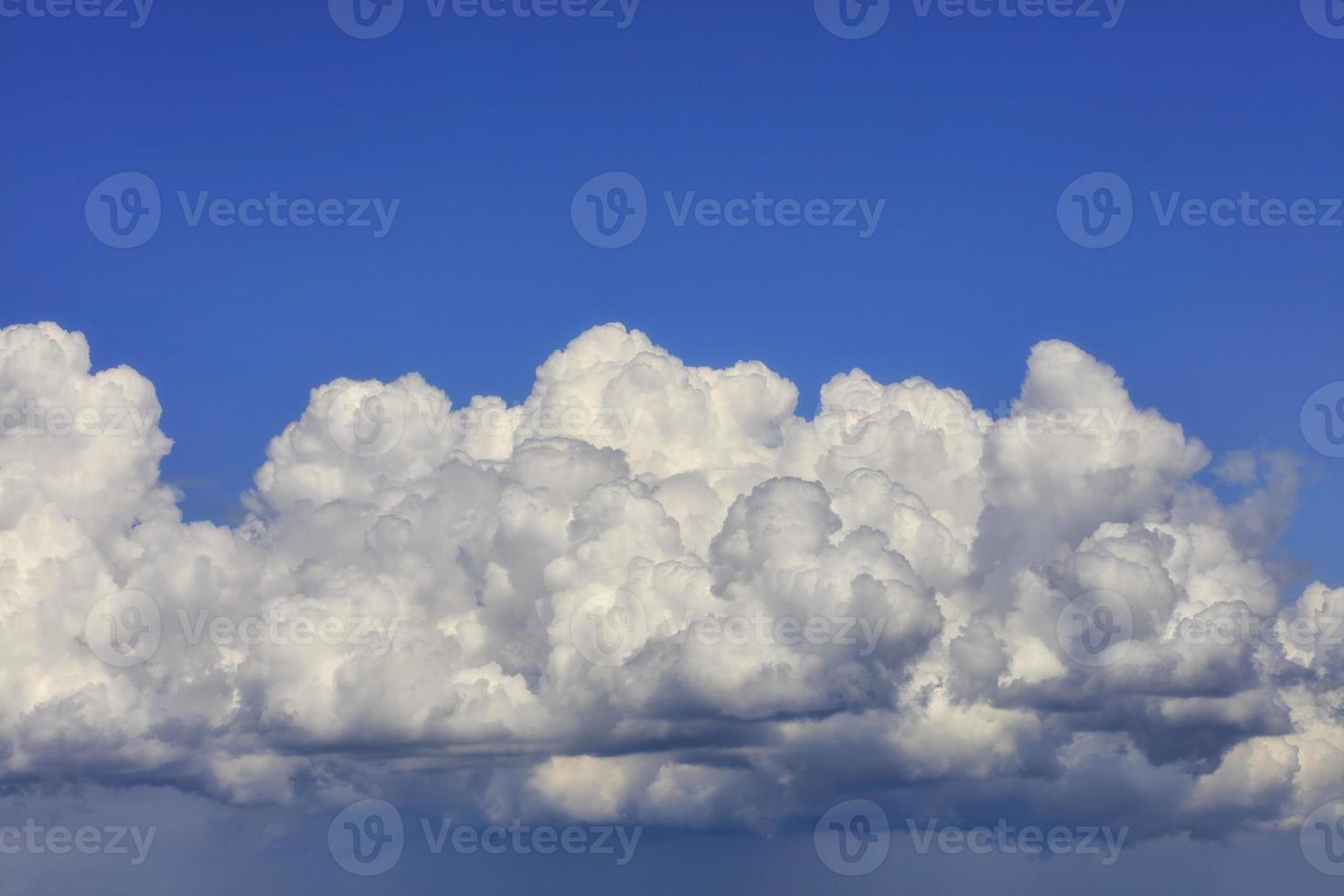 gran nube blanco-gris se condensa en una nube lluviosa en el cielo azul, primer plano. foto