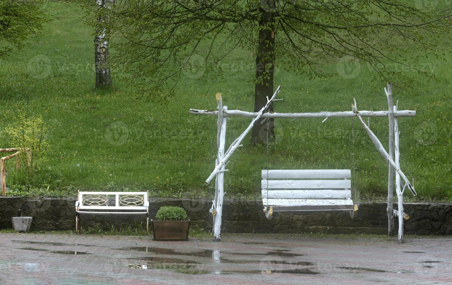 White swings in the garden after the summer rain. photo