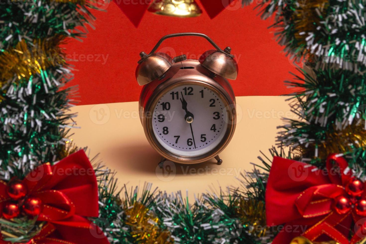 Close up. Christmas wreath with decorations and alarm clock on a colored background. Copy photo