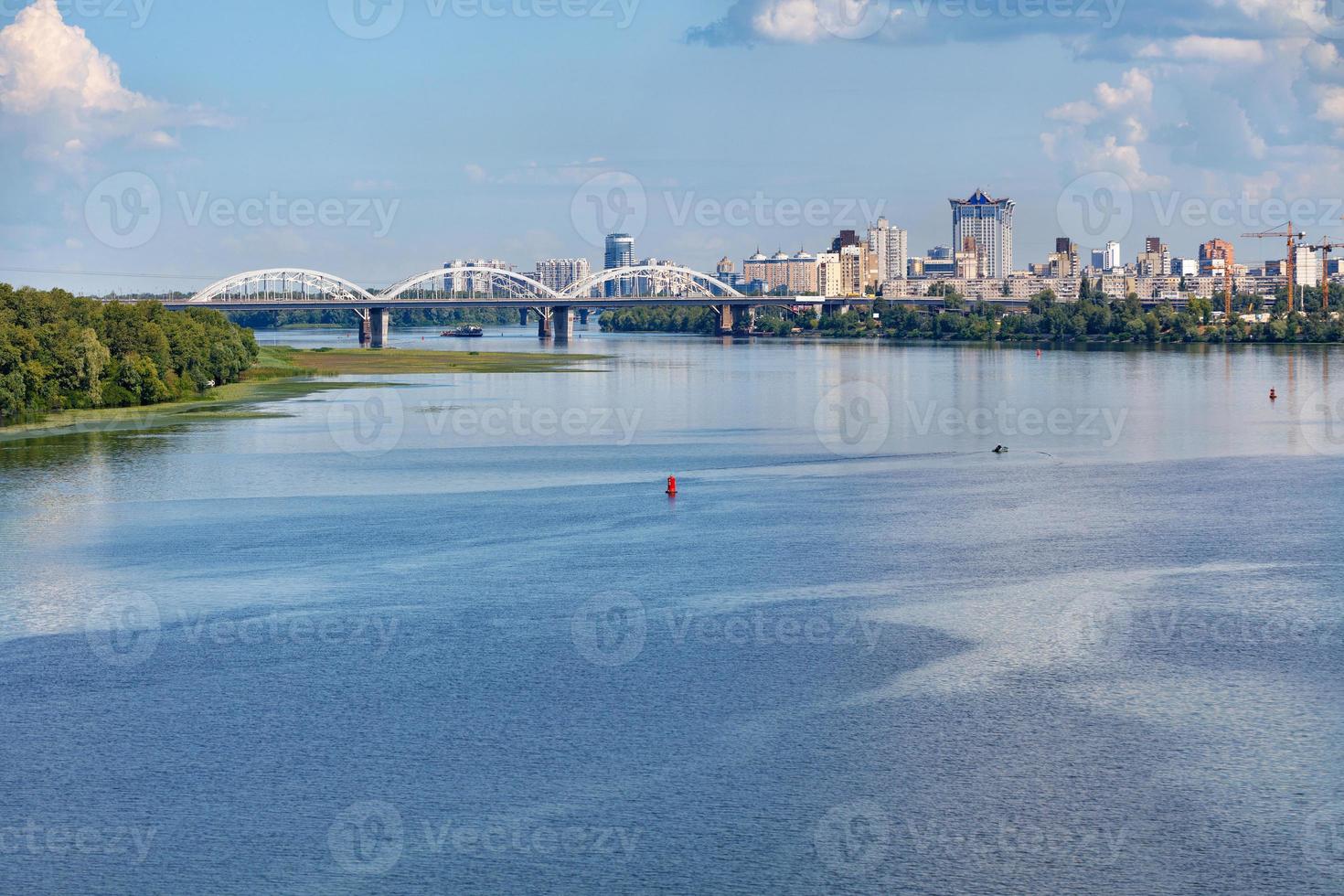 A view of the Dnipro, the railway bridge and new residential areas of Kyiv on the horizon of the coast. photo