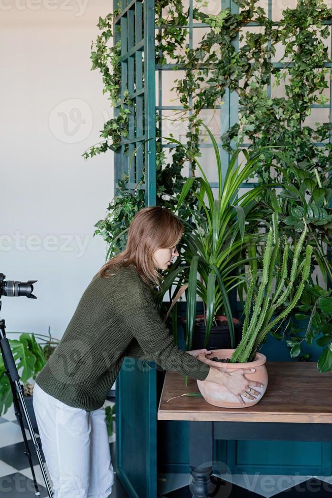 Young woman taking care of the plants at home photo