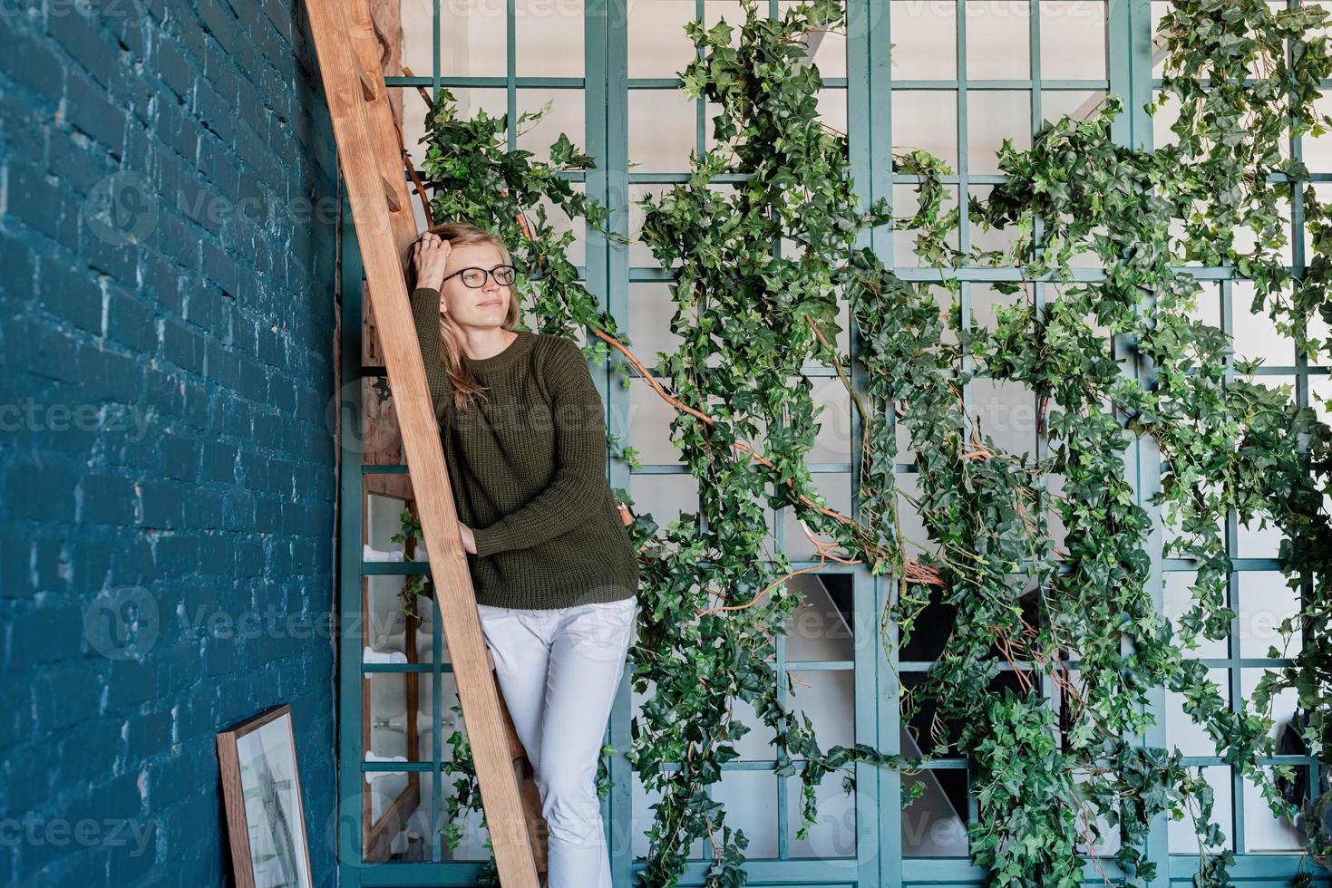 Young woman taking care of the plants at home photo