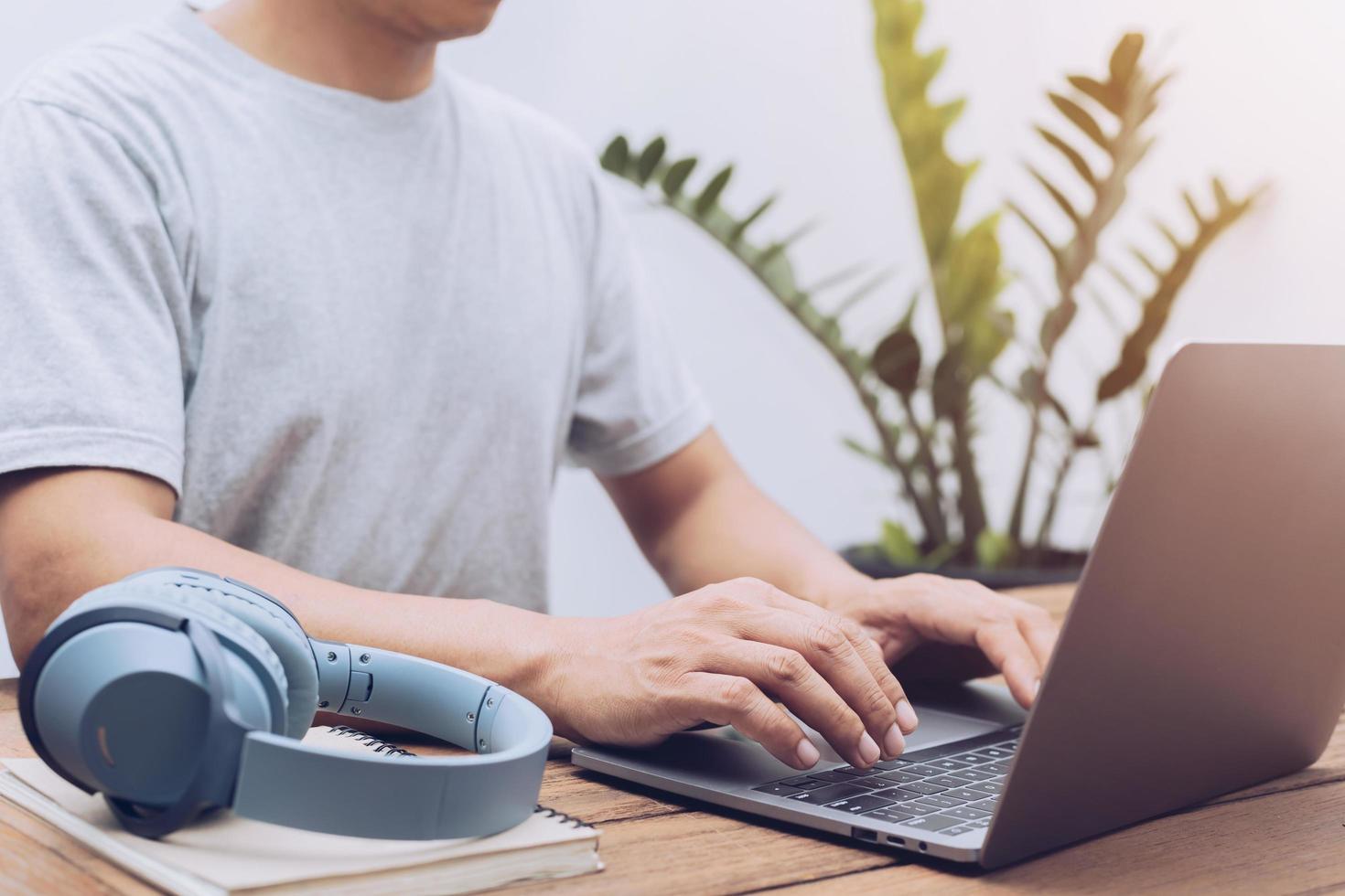 young man using laptop typing on keyboard photo