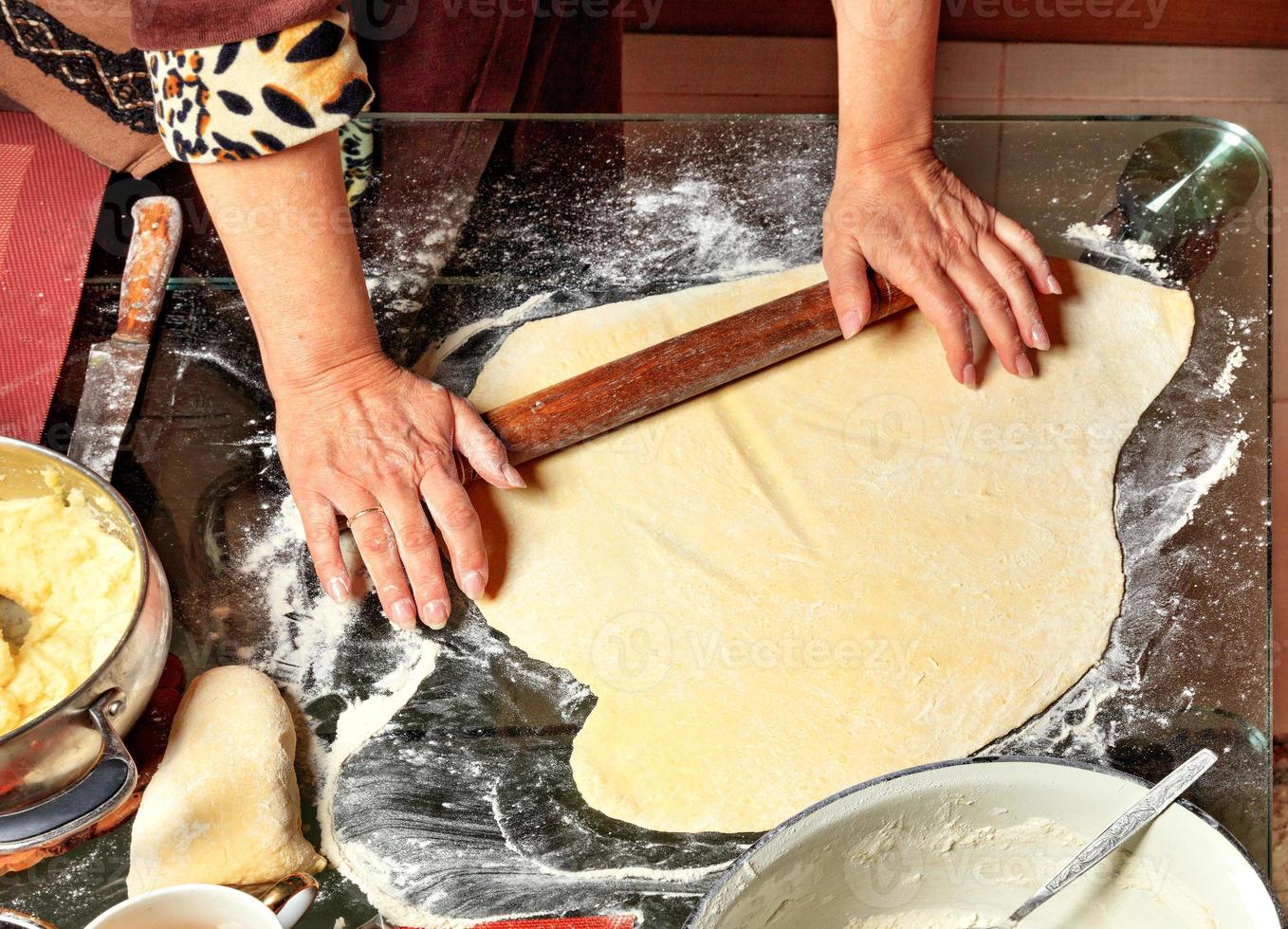 una mujer extiende la masa con un rodillo de madera. cocina tradicional ucraniana. foto