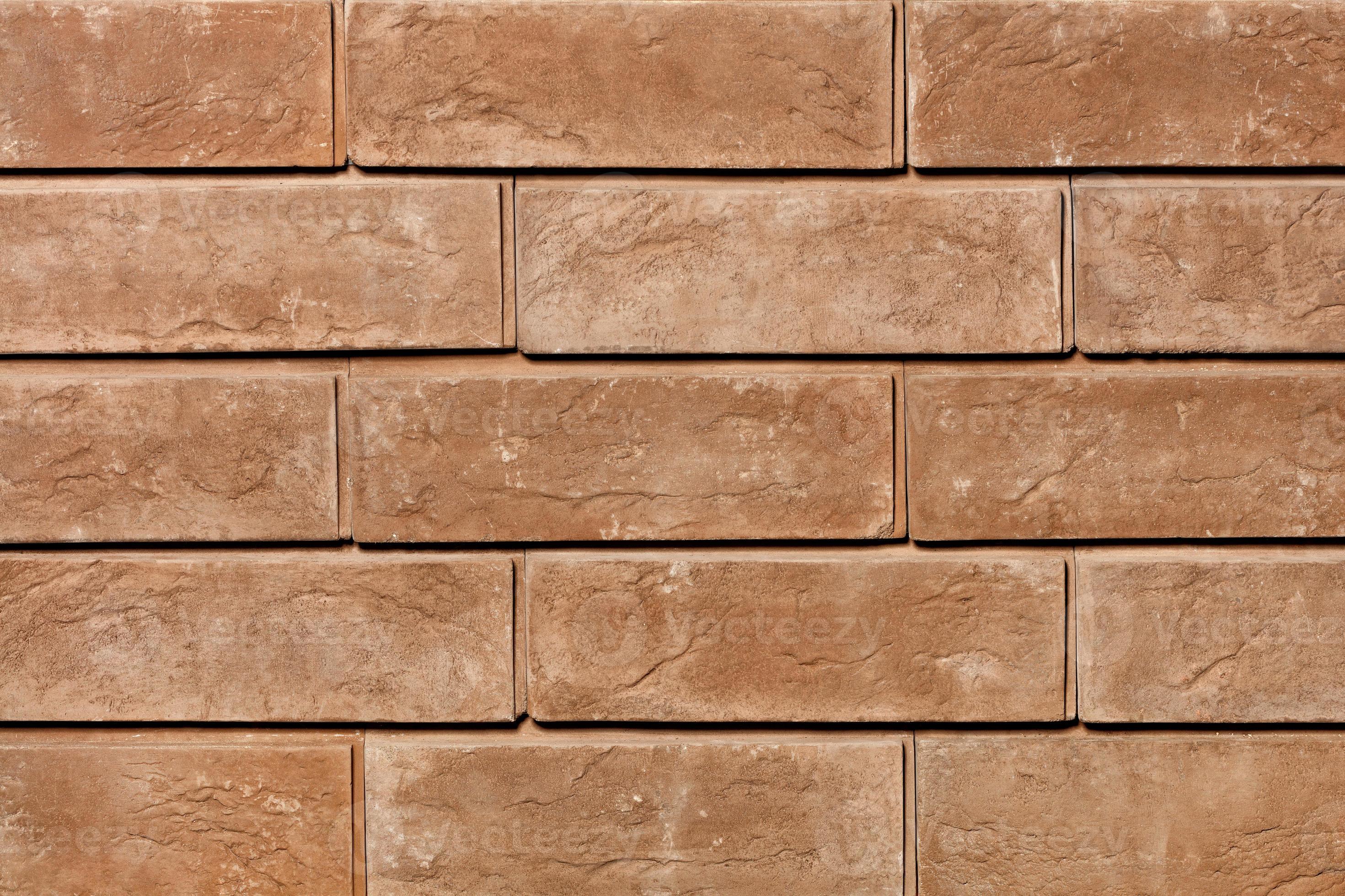 Texture of brown brick tiles on the facade of the wall closeup
