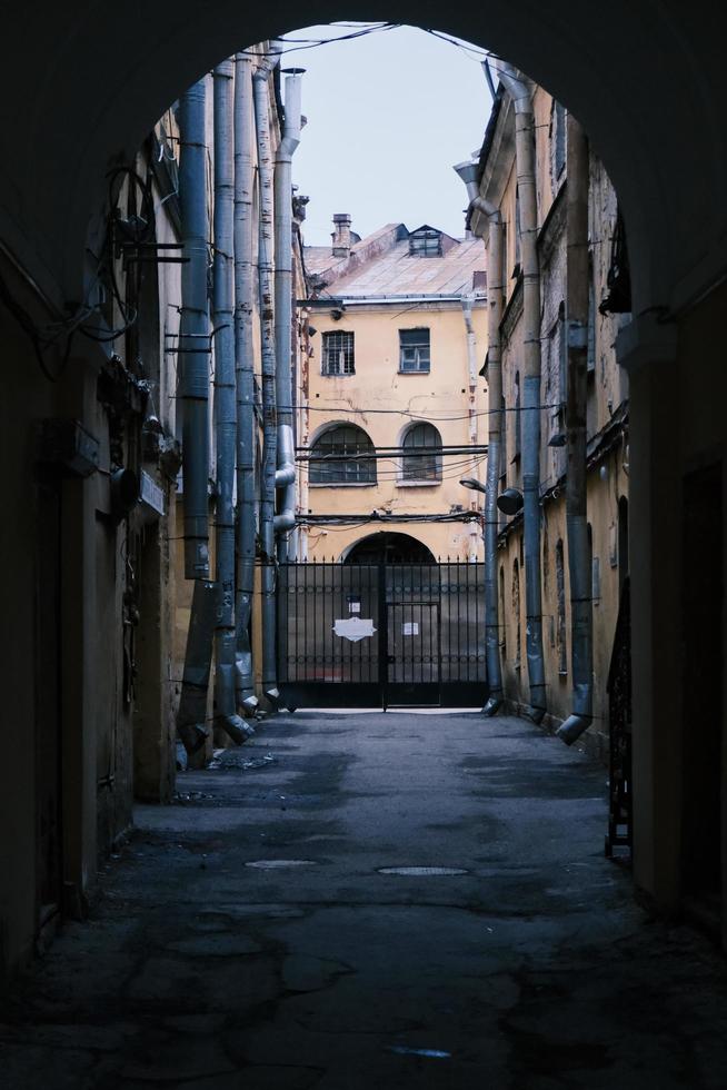 view on a narrow street that goes to a dead-end from an arch of a building photo