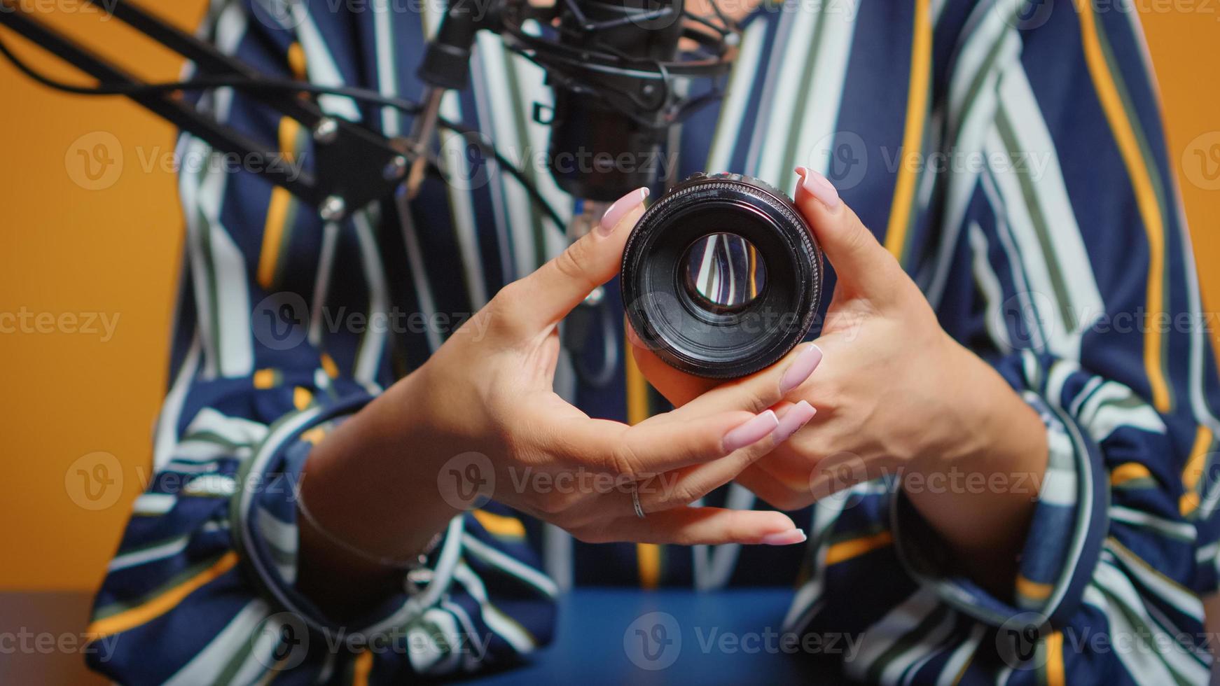 Close up of content creator making a review for new camera lens photo