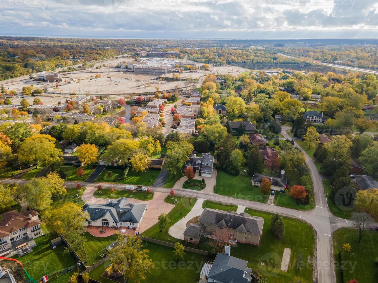 Aerial view of residential neighborhood in Northfield, IL. Lots of trees starting to turn autumn colors. Large residential homes, some with solar panels. Meandering streets photo