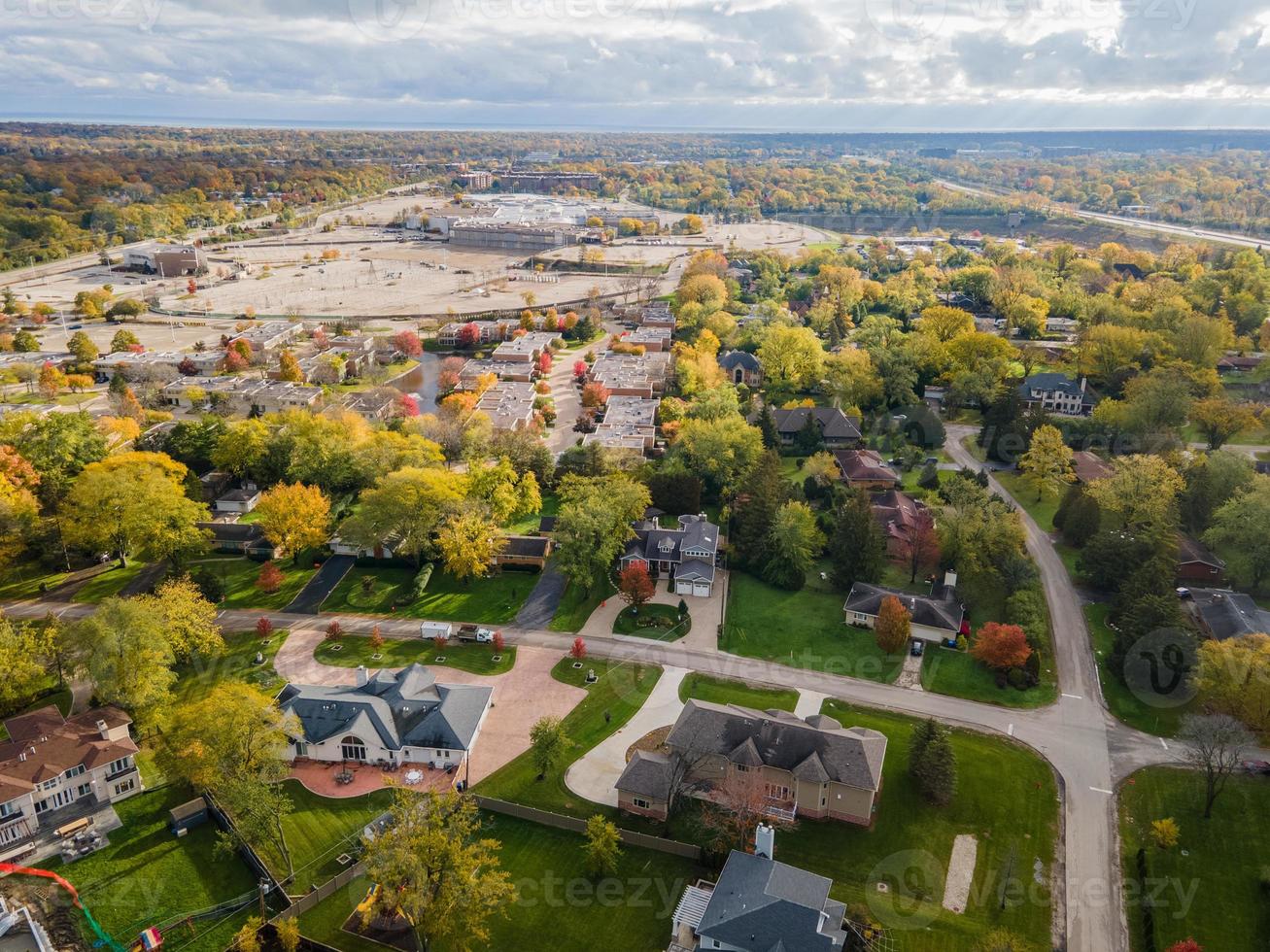 vista aérea del barrio residencial en northfield, il. muchos árboles empiezan a cambiar de color otoñal. grandes casas residenciales, algunas con paneles solares. calles serpenteantes foto