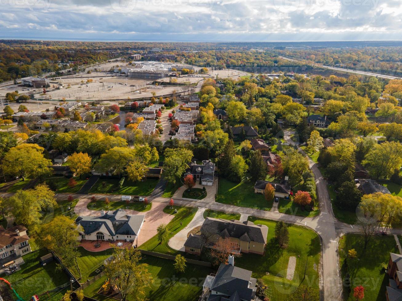 vista aérea del barrio residencial en northfield, il. muchos árboles empiezan a cambiar de color otoñal. grandes casas residenciales, algunas con paneles solares. calles serpenteantes foto