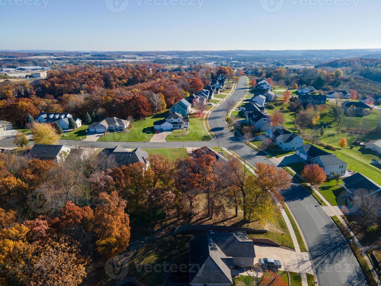 Aerial view of Eau Claire, Wisconsin, residential neighborhood in autumn.  Wide streets with curbs and sidewalks. Large homes and yards.  Park nearby. Blue sky in the horizon. photo