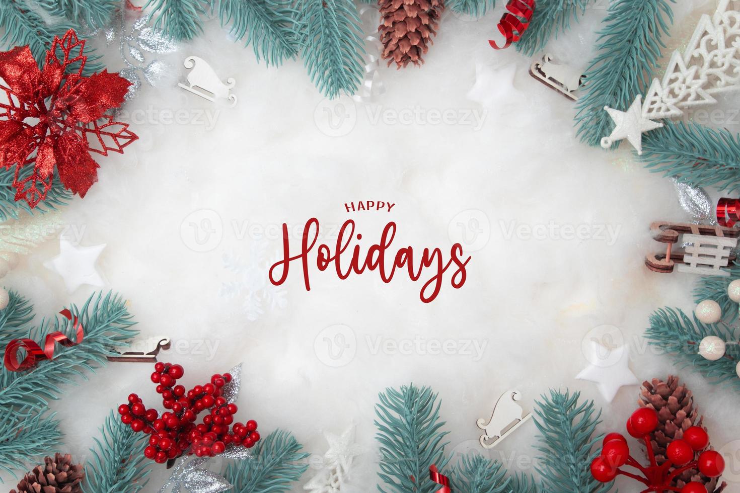 Happy Holidays text with frame made of Christmas decorations flat lay on snowy background with copy space photo