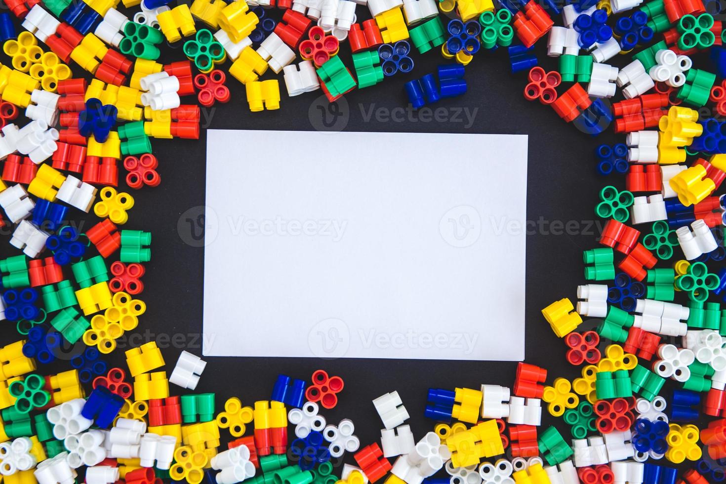 Multicolored plastic blocks on a black background with a place for text photo