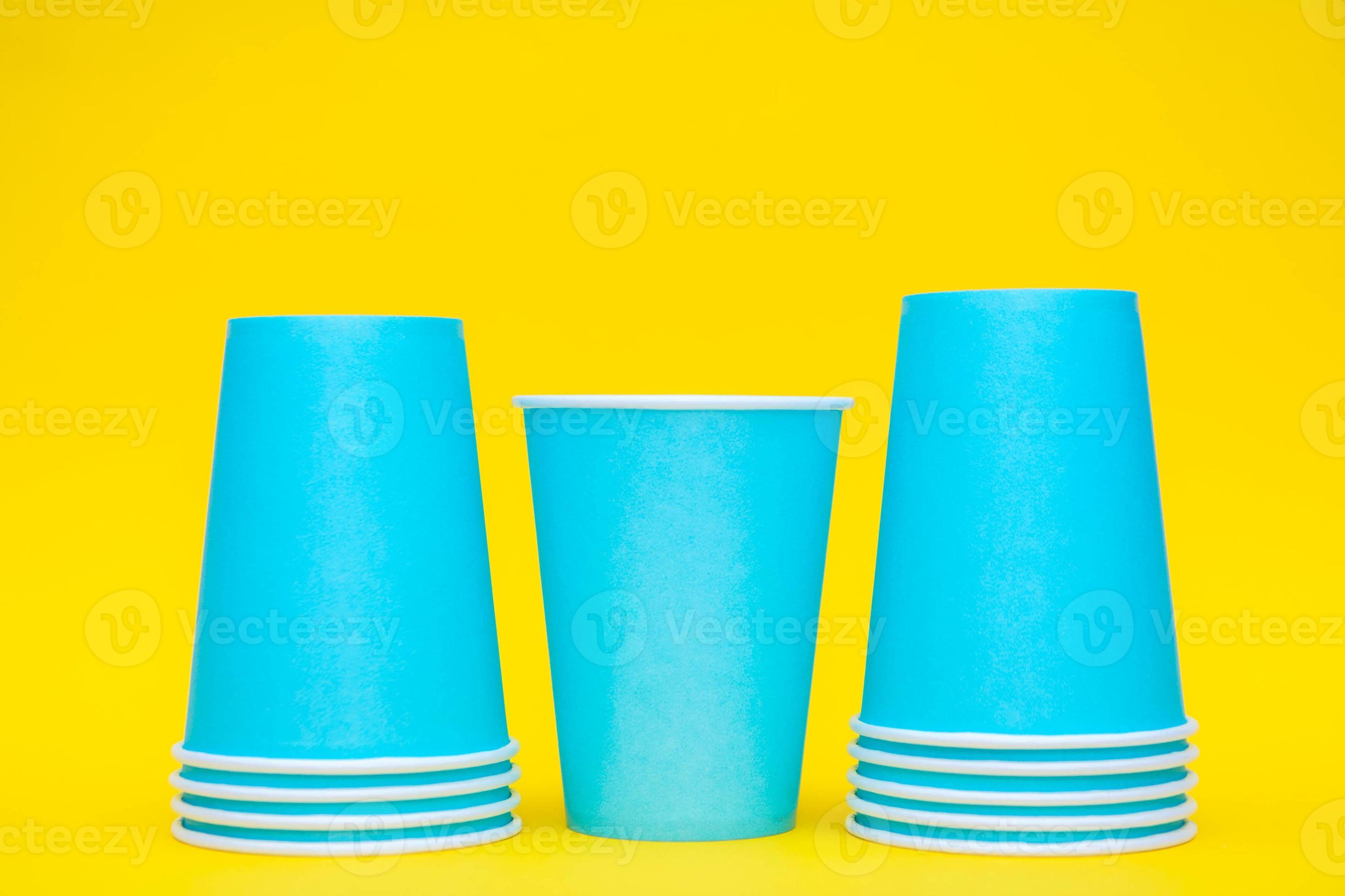 Blue paper cups placement in a line on yellow background 4718243 Stock