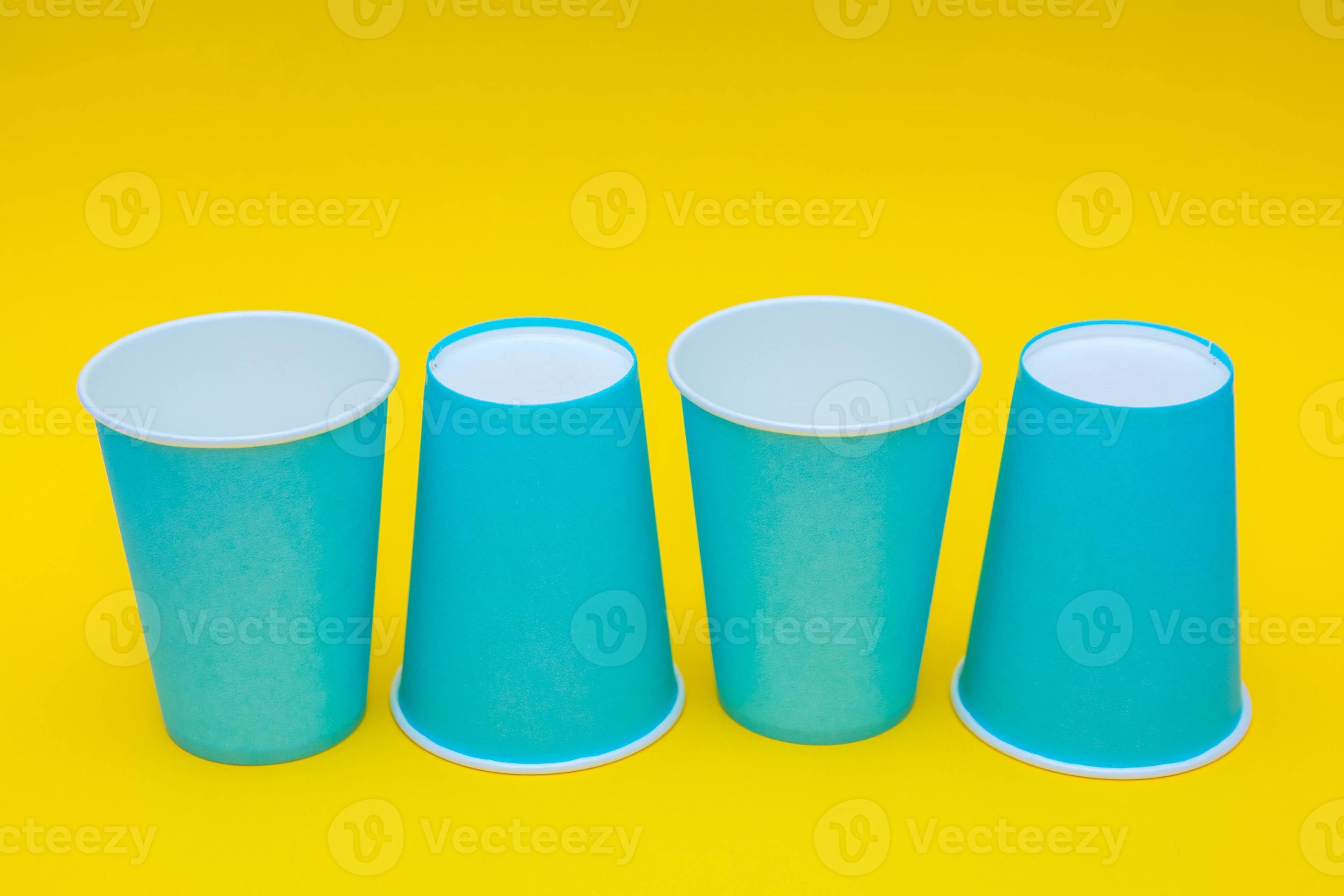 Blue paper cups placement in a line on yellow background 4718247 Stock
