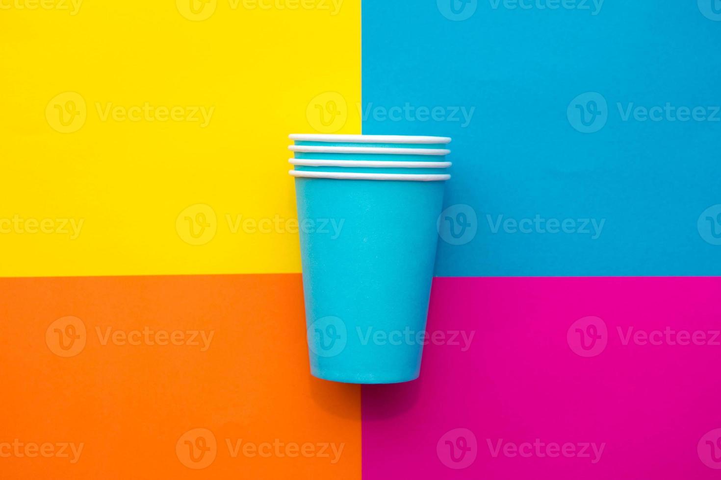 Blue paper disposable cups on beautiful multicolored background photo