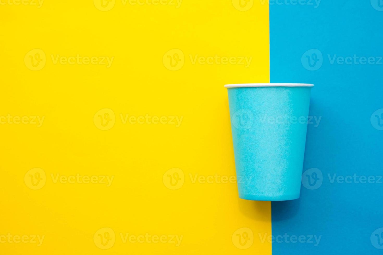 Blue paper disposable cup yellow and blue background photo