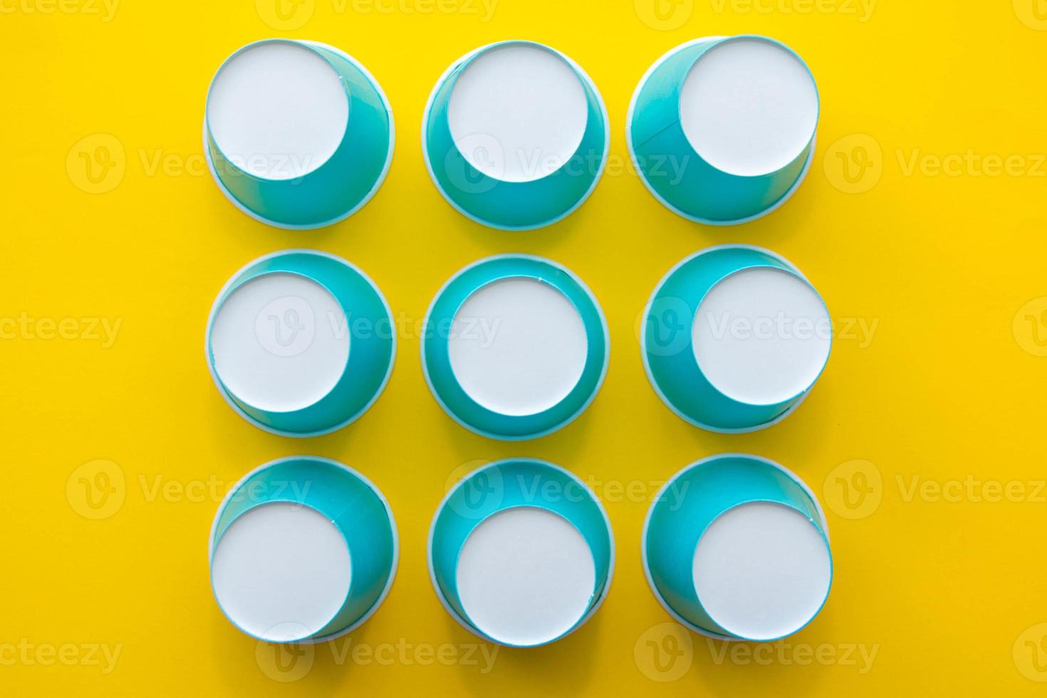 Patrón de vasos desechables de papel azul sobre fondo amarillo foto