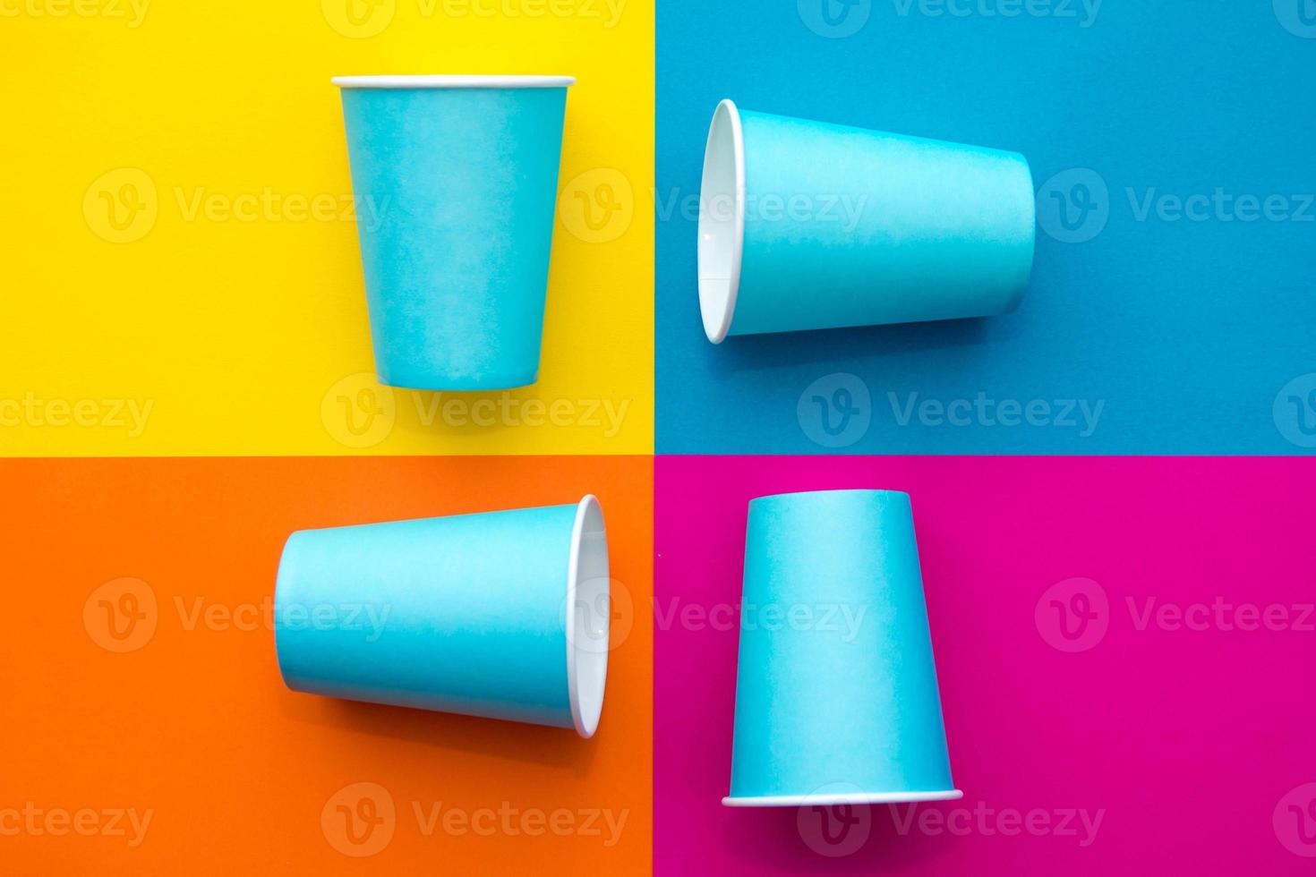 Vasos desechables de papel azul sobre un hermoso fondo multicolor foto