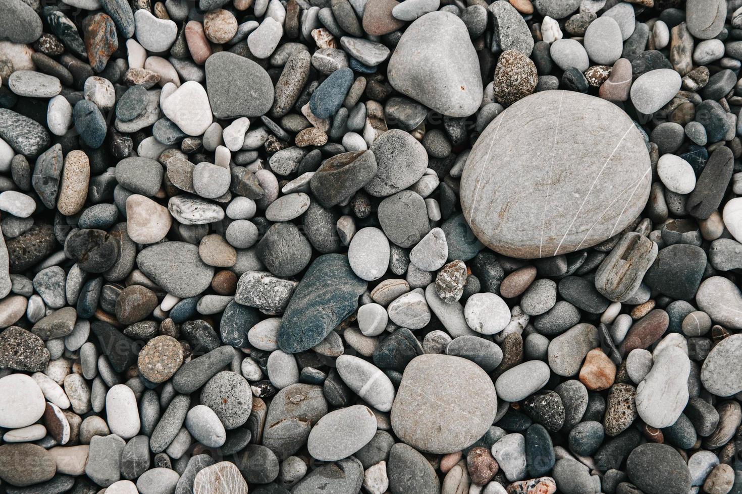 patrón de grava de piedras de colores húmedos. Fondo de guijarros de naturaleza abstracta foto