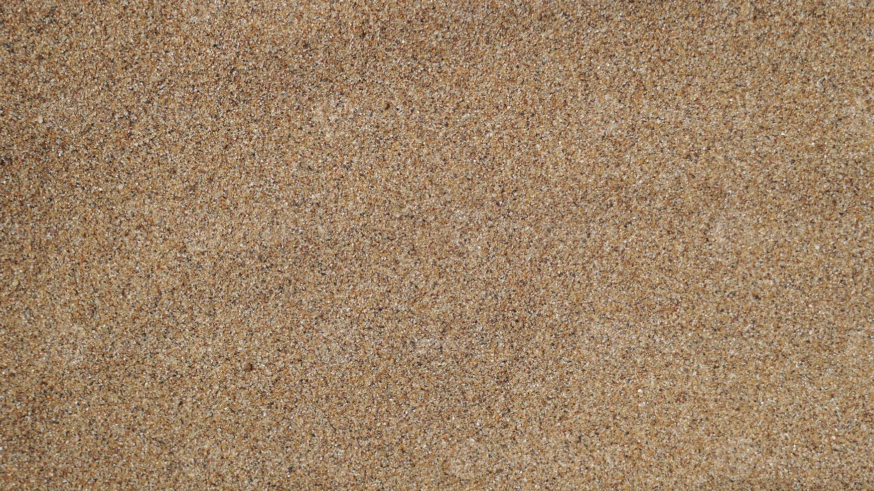 Sand texture background. Warm yellow clean beach sand for backgrounds. Nature pattern photography for backdrop. Concept for travel, tropics, beach vacations and holidays. photo