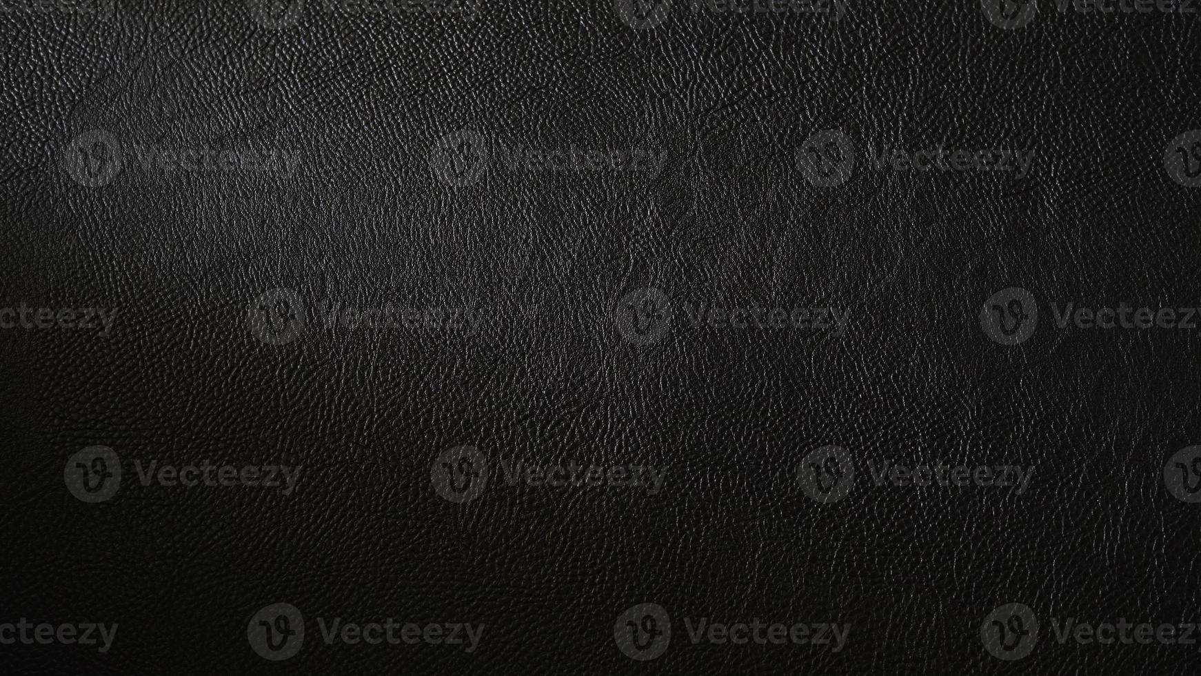 Macro shot of detailed black leather background. Dark textured close-up on quality leather parchment. Can be used in the background for luxury products and designs. photo