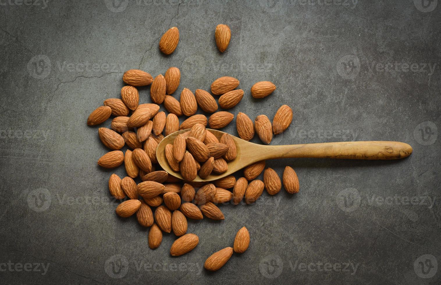 Almonds on dark background top view on the table, Close up roasted almond nuts natural protein food and for snack photo