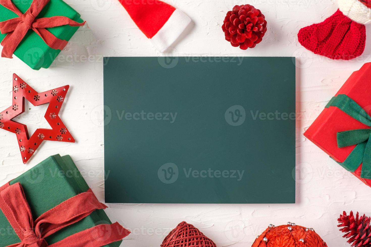 blackboard with christmas gift box and decor ornament on white concrete table photo