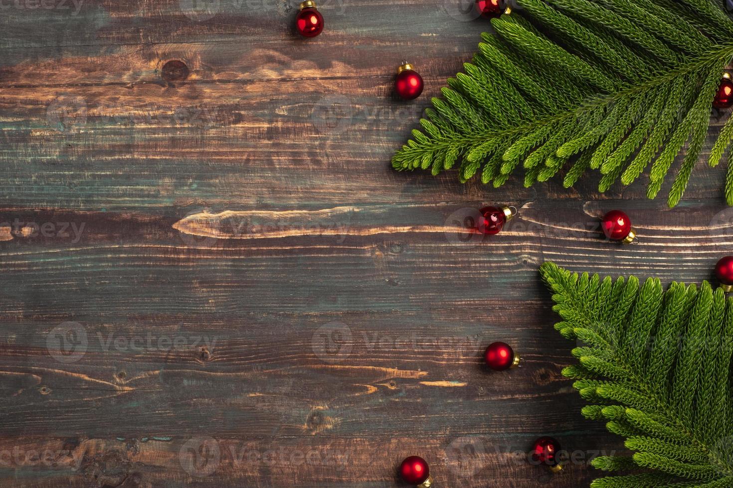 Hoja de pino de navidad con adornos decorativos sobre mesa de madera foto