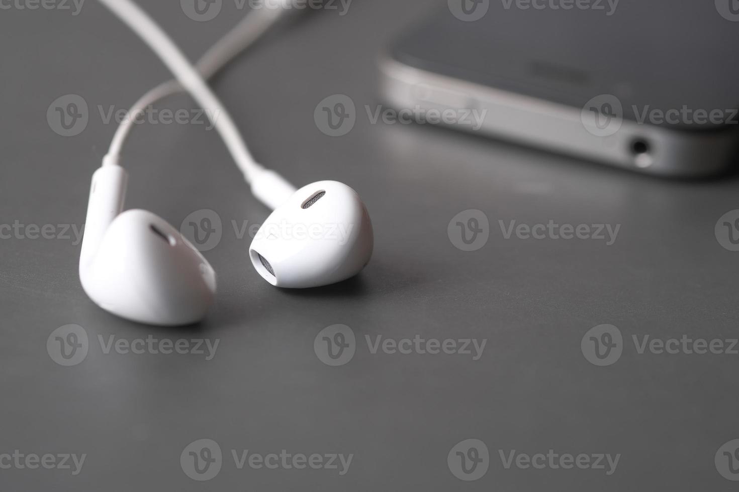 smart phone and headphone on wooden background . photo