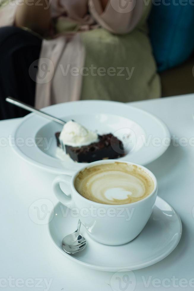 a cup of late coffee with flower shape design on top at cafe photo