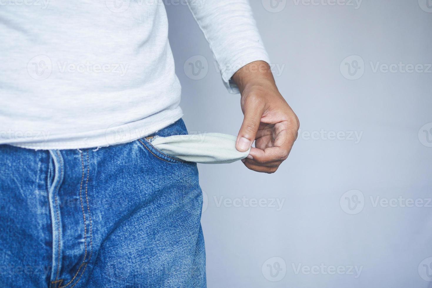 young man shows empty pant pocket with copy space photo