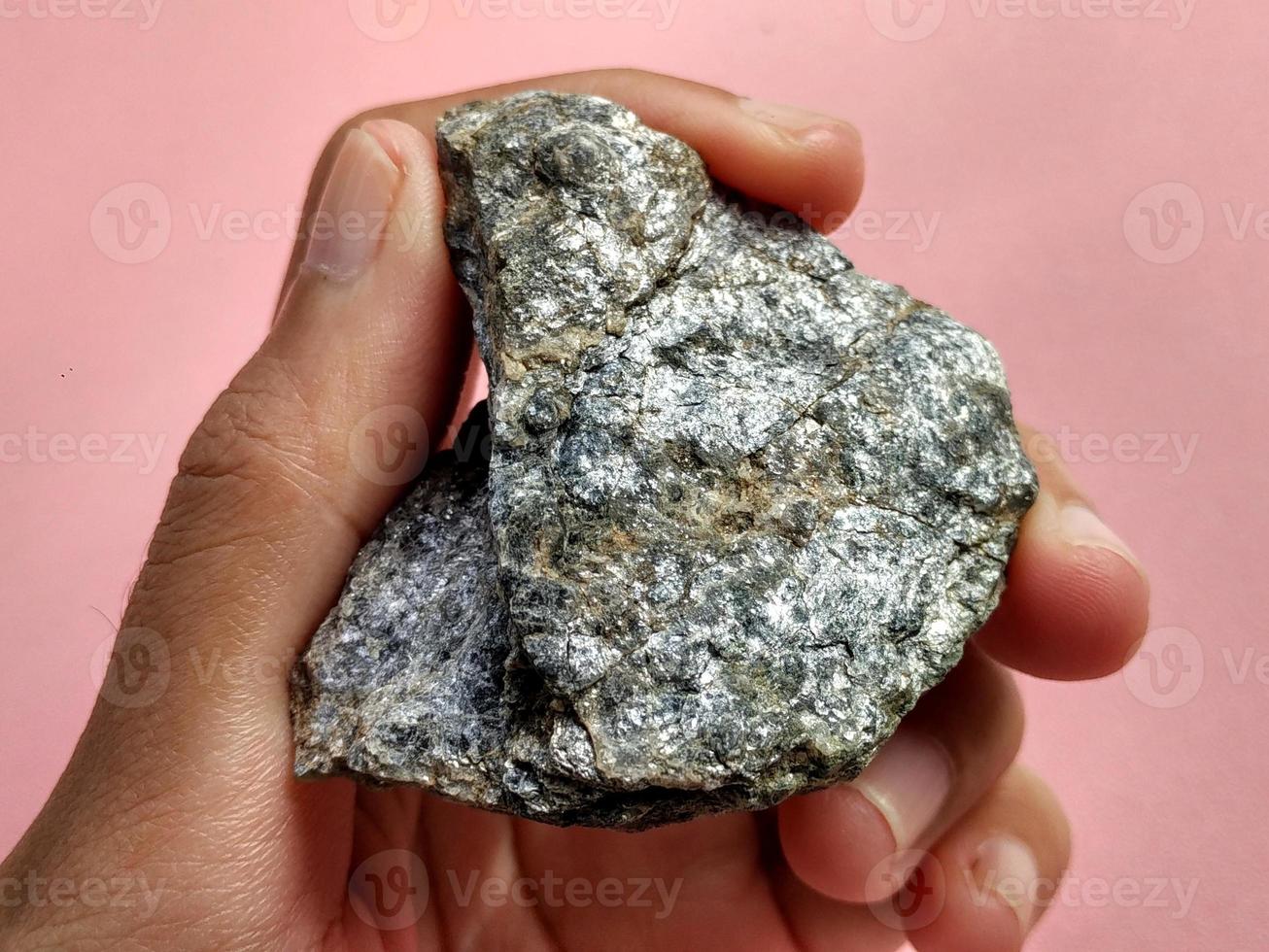 Schist Mica metamorphic rock foliated structure on pink background. With quartz, muscovite, garnet, chlorite, calcite, apatite on Melange tectonic zone in Karangsambung, Indonesia. Ophiolite area photo