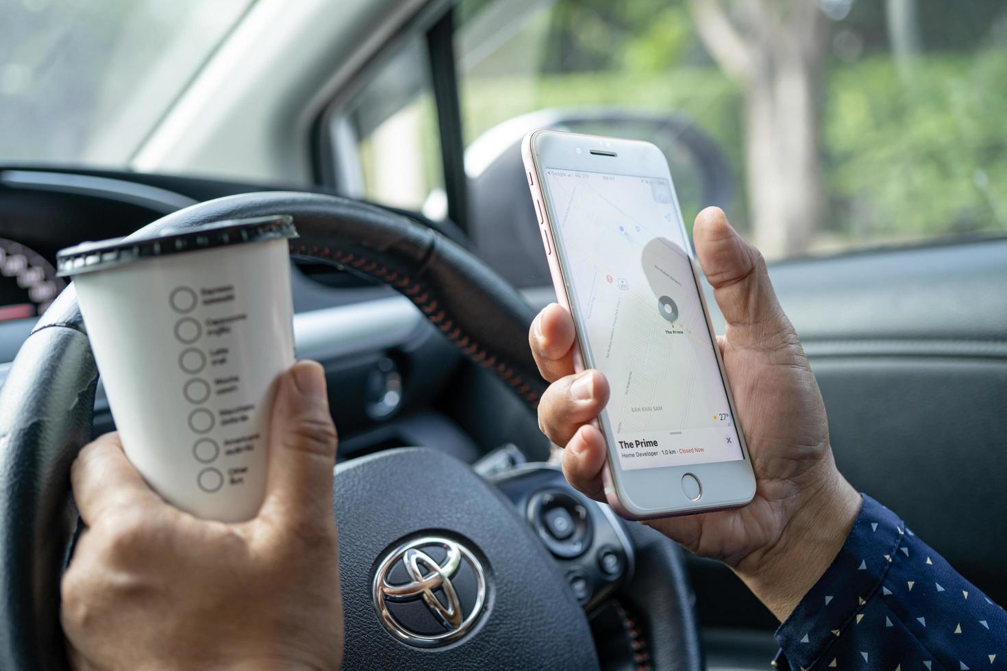 Bangkok, Tailandia 2021 - Señora asiática en coche, sosteniendo café helado, teléfono foto