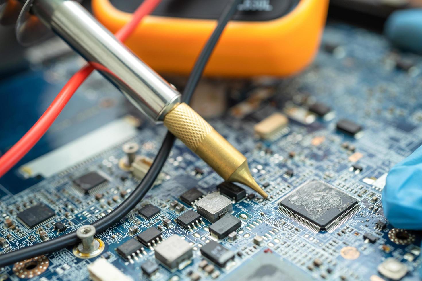 technician repairing inside of hard disk by soldering iron. Integrated Circuit. the concept of data, hardware, technician and technology. photo