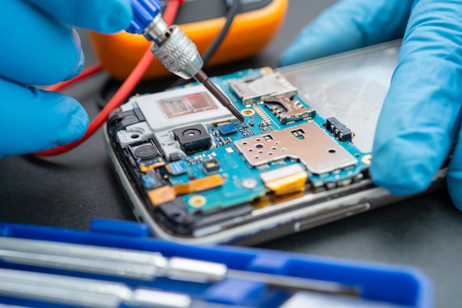 Technician repairing inside of mobile phone by soldering iron. Integrated Circuit. the concept of data, hardware, technology. photo