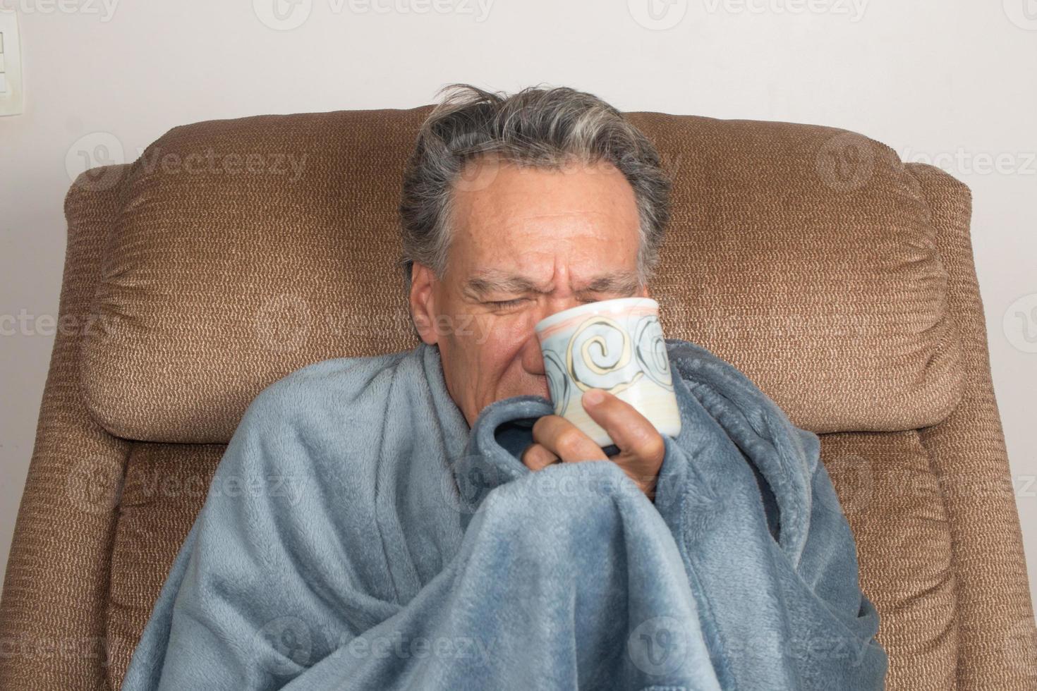 Mature Man not Feeling Well Wrap in a Blanket Drinking Tea photo