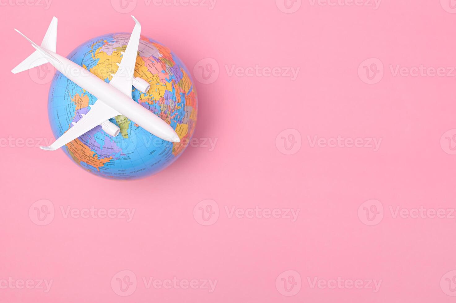 A plane flying over the earth on a pink background photo