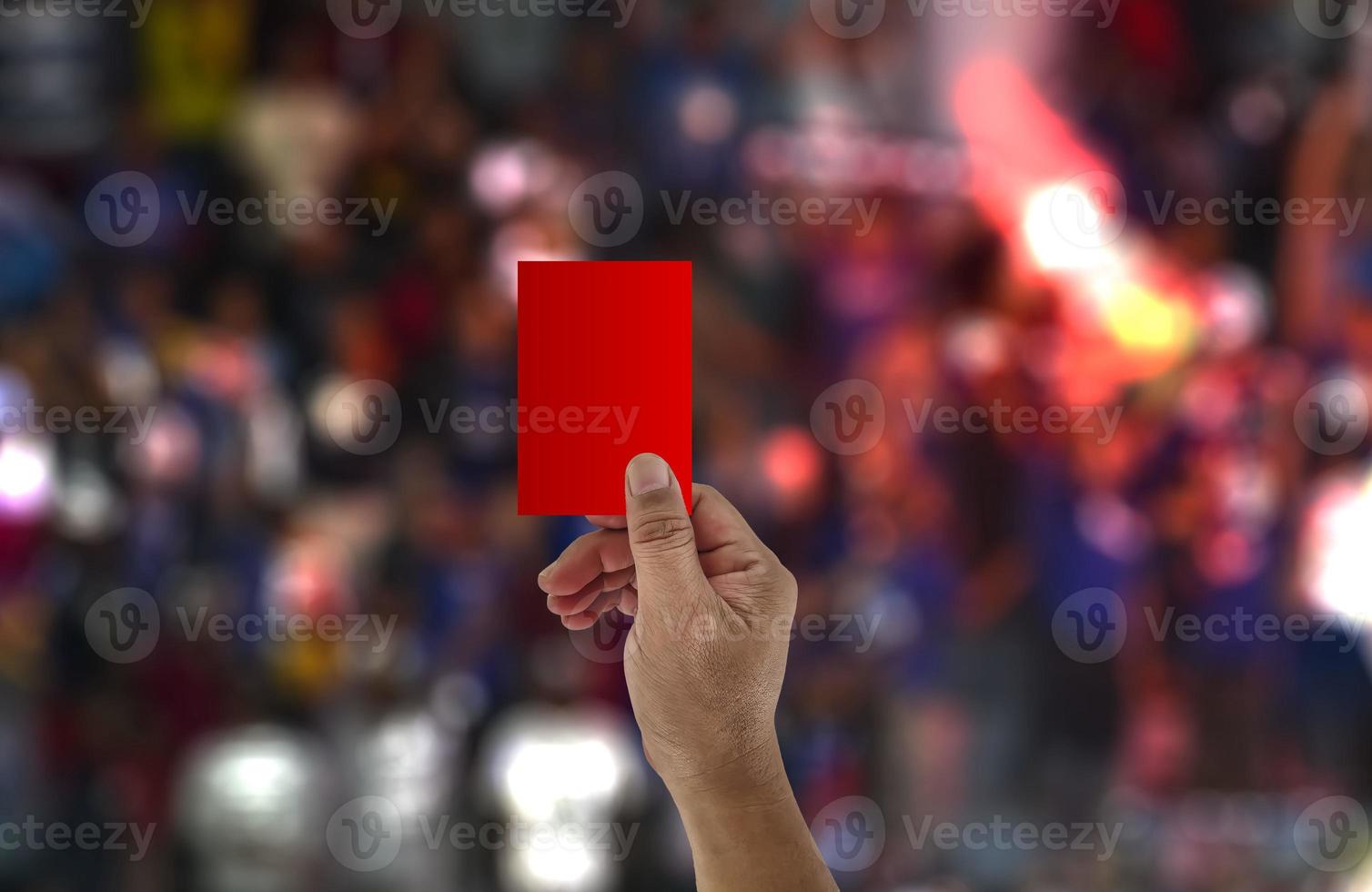 The referee raises his hand and shows a red card in a football match. photo