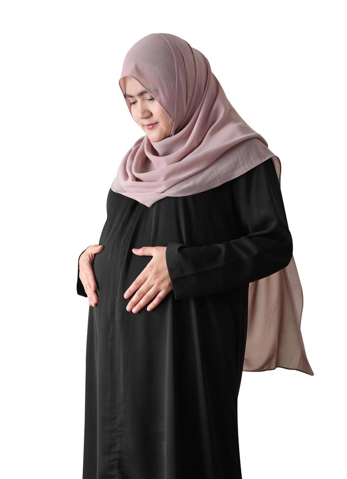 Mujer asiática embarazada vistiendo hijab sobre fondo blanco. foto