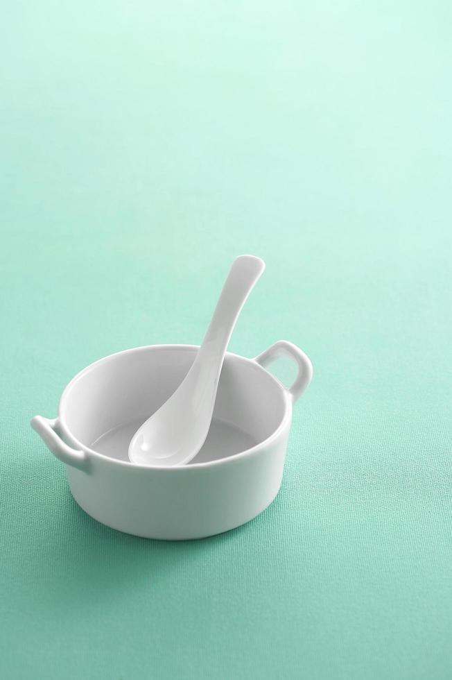 Ceramic spoon in cup on pastel background photo
