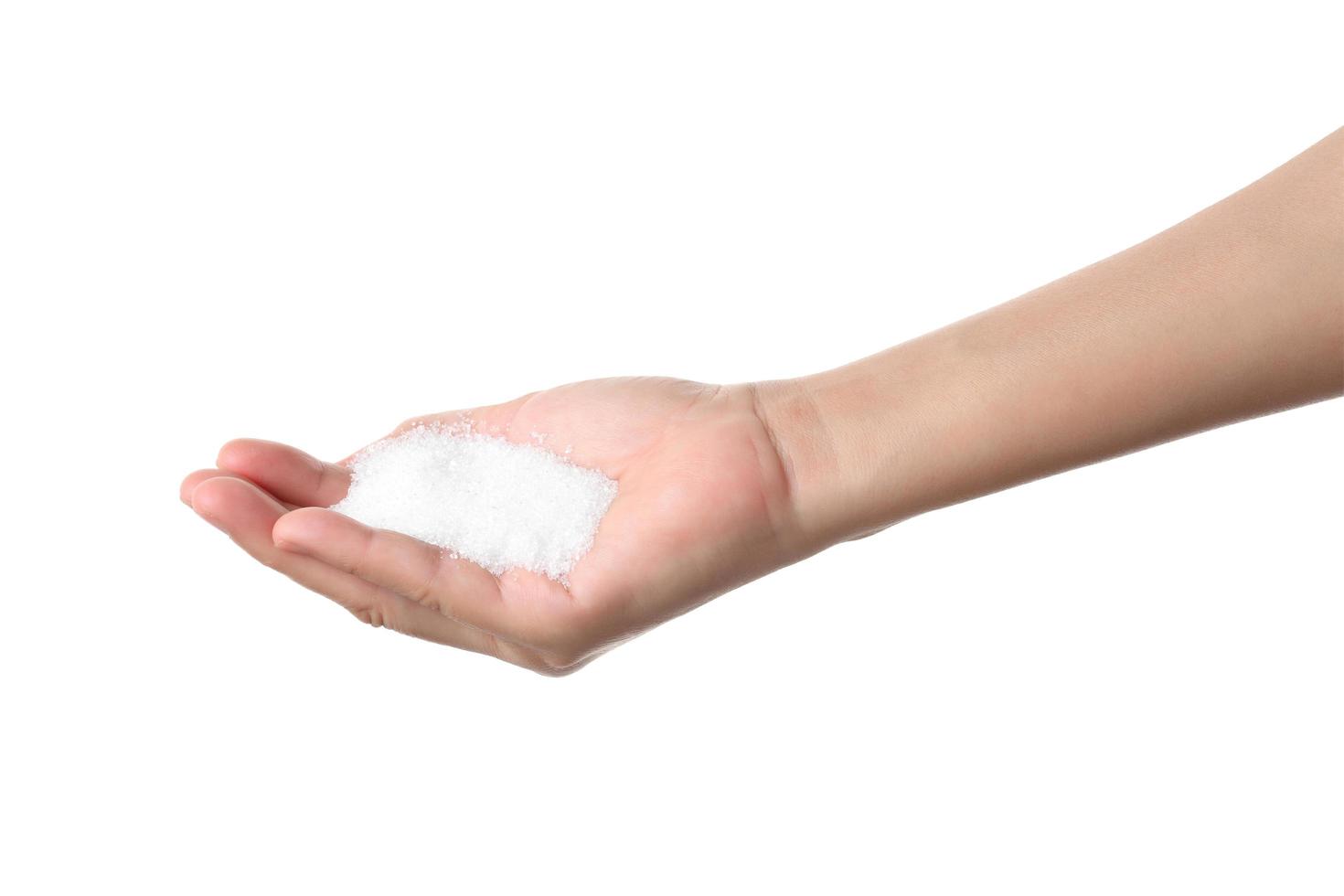 Hand holding sugar on white background photo