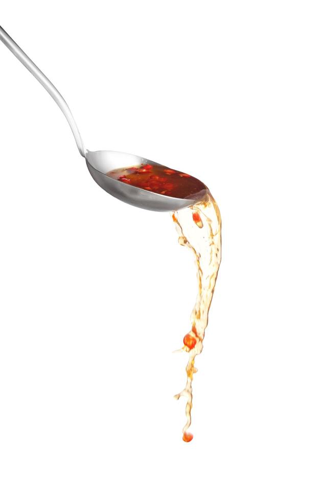 Dipper pouring spicy noodle soup on white background, Soup for sukiyaki from chicken and fish photo