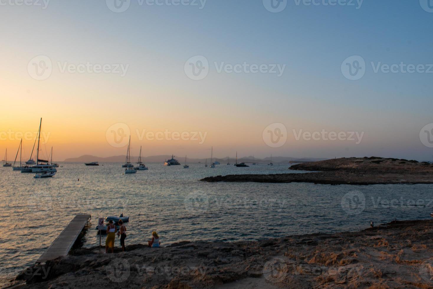People watching the sunset on the beach of Ses Illietes on the Island of Formentera in the summer of 2021. photo