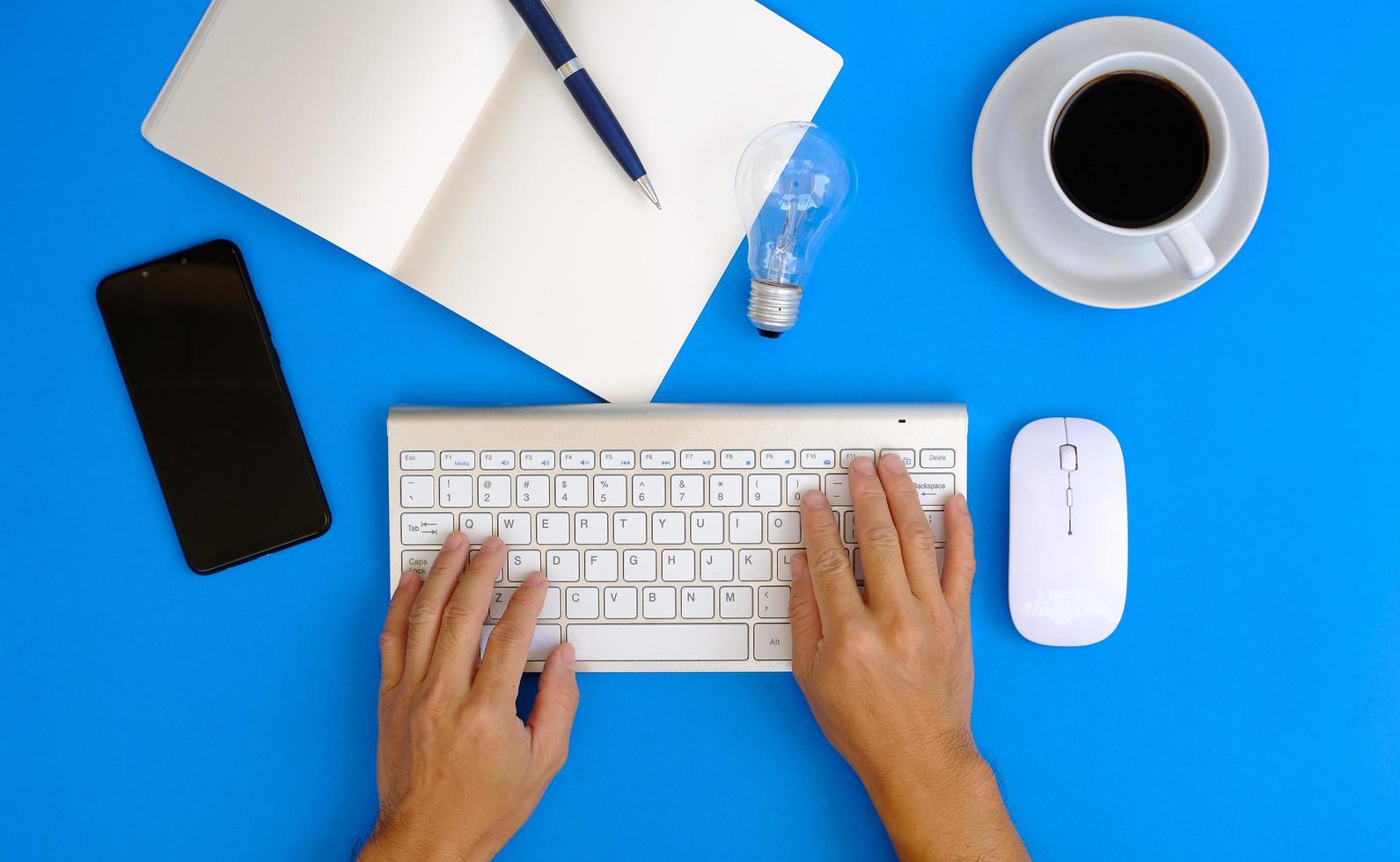 Hands of a man working on a modern laptop Banking and money themes on a blue background in an office. photo