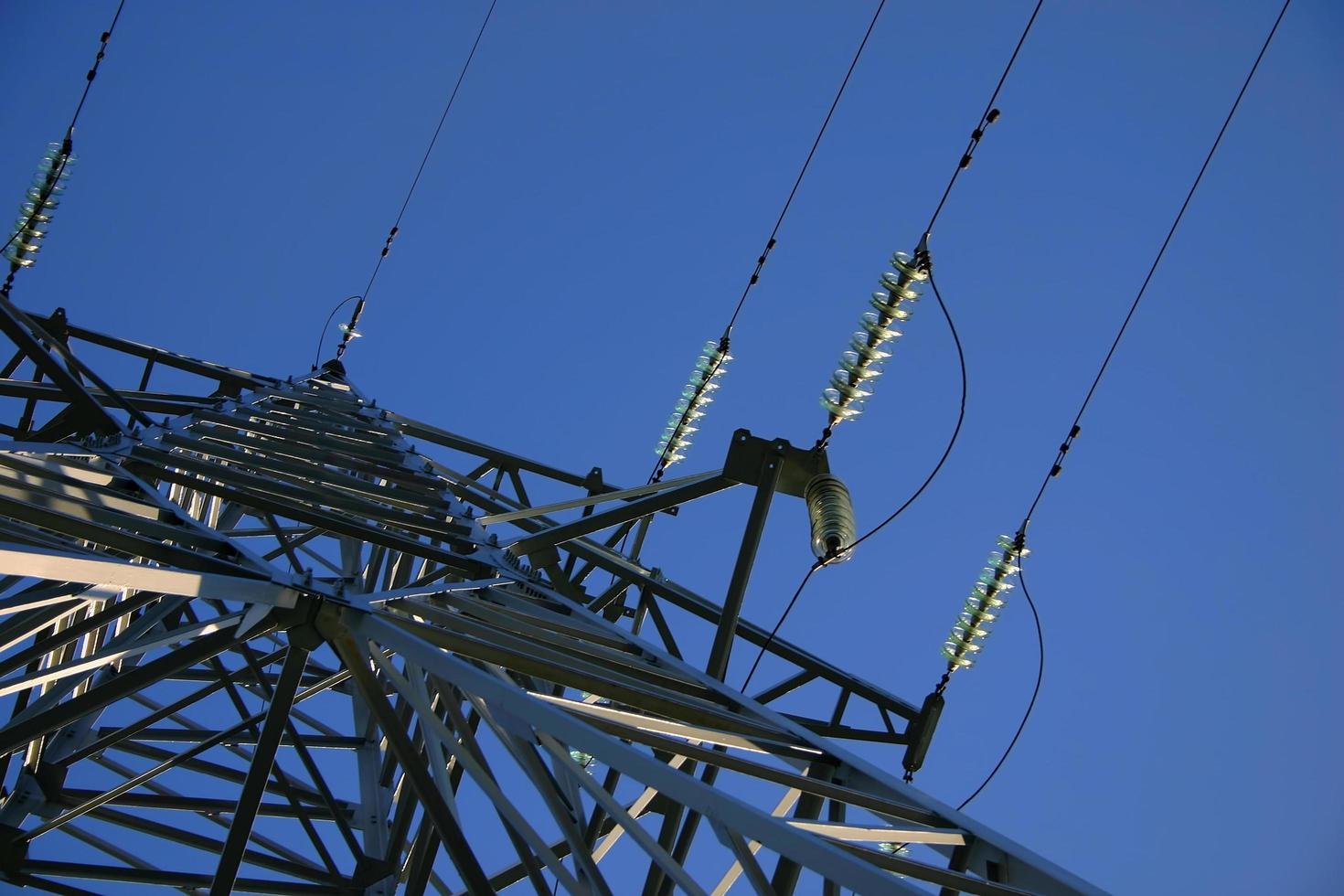 High power lines against clear blue sky photo