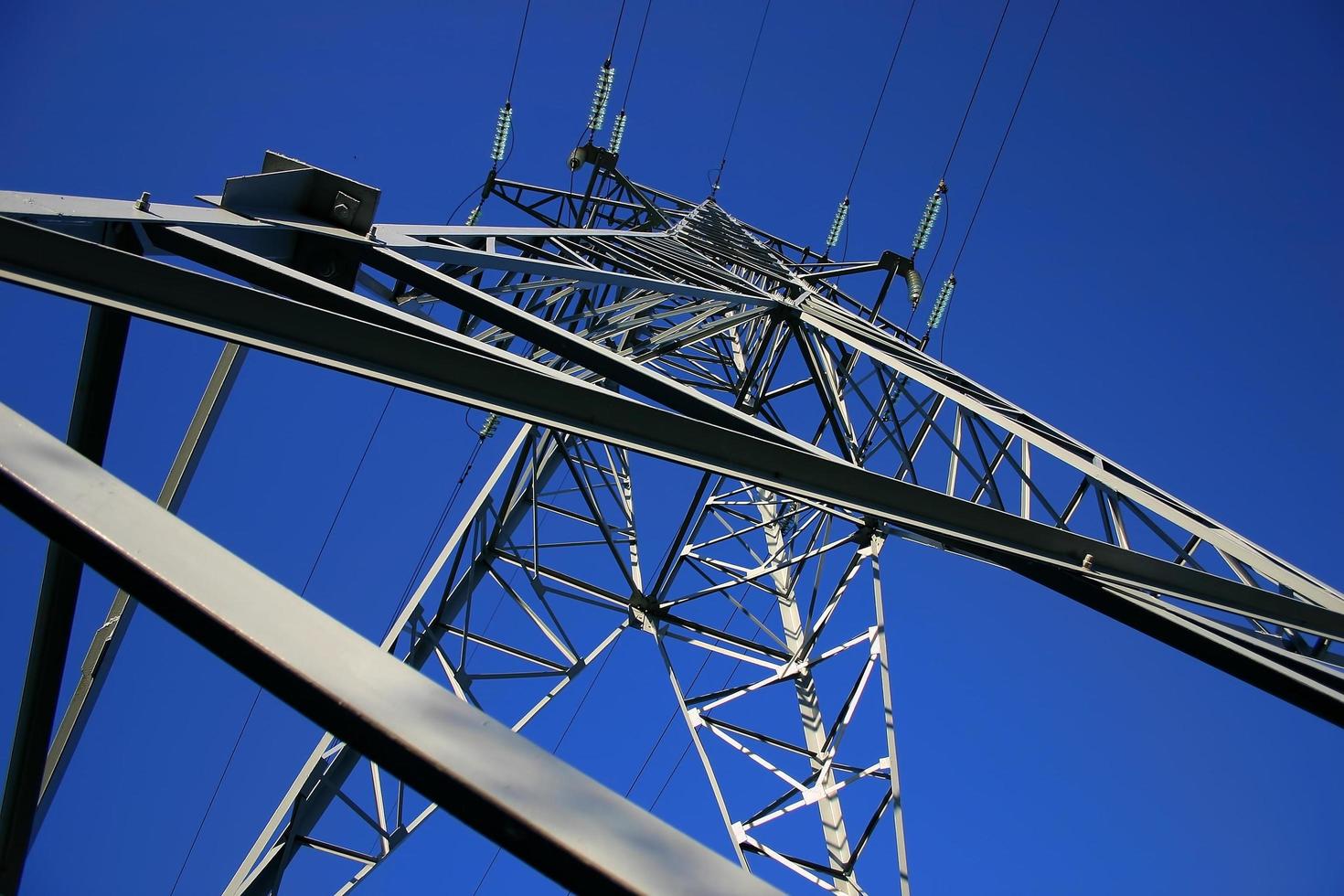 High power lines against clear blue sky photo